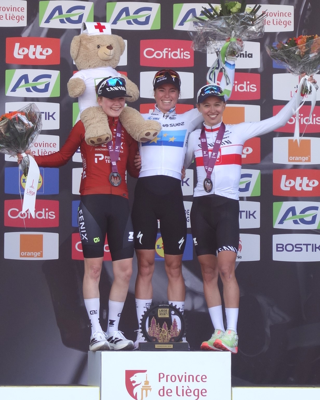 Demi Vollering celebra en el podio de Lieja-Bastona-Lieja 2026 junto a Puck Pieterse y Katarzyna Niewiadoma