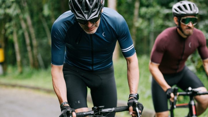 Ciclista rodando con culotte y maillot técnico en una carretera despejada