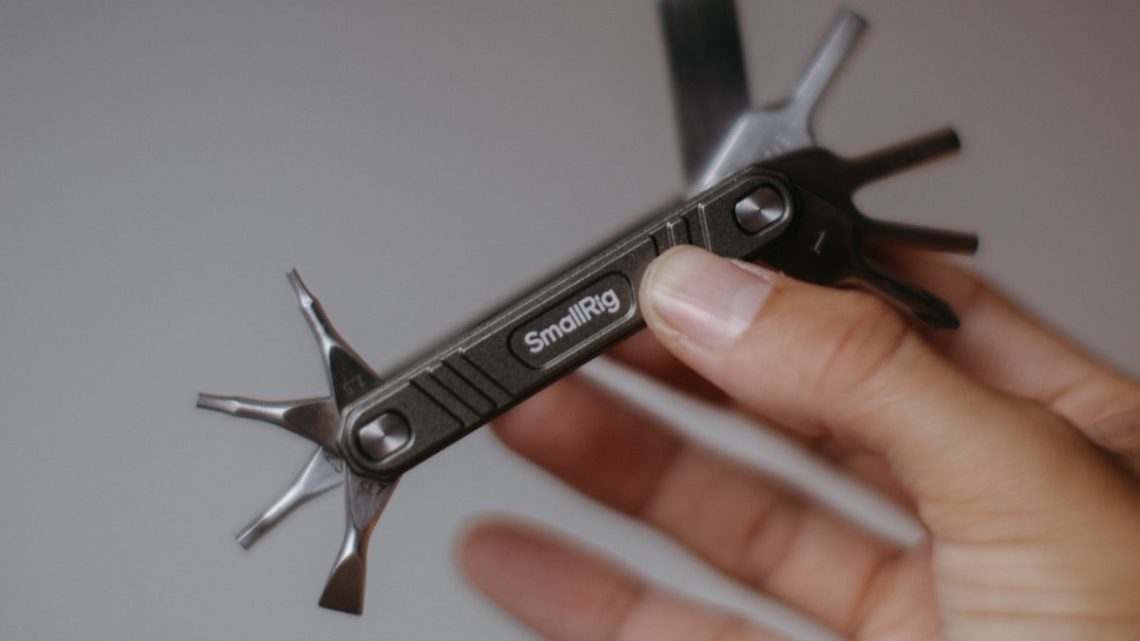 Mano sosteniendo una multiherramienta de bicicleta plegable con varios accesorios desplegados