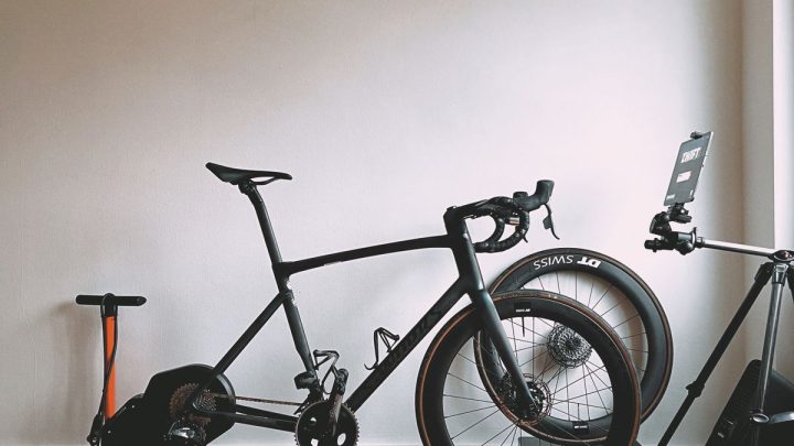 Bicicleta de carretera montada en un rodillo de entrenamiento en un salón luminoso