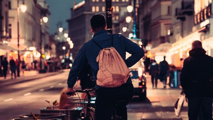 Ciclista circulando de noche por una calle iluminada de la ciudad