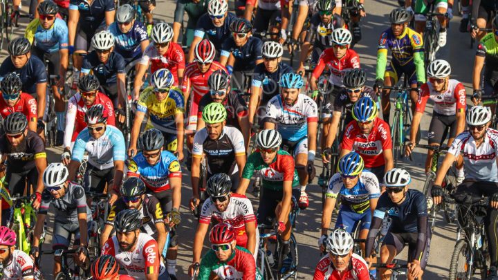 Pelotón de ciclistas con maillots de colores vivos durante una carrera por carretera