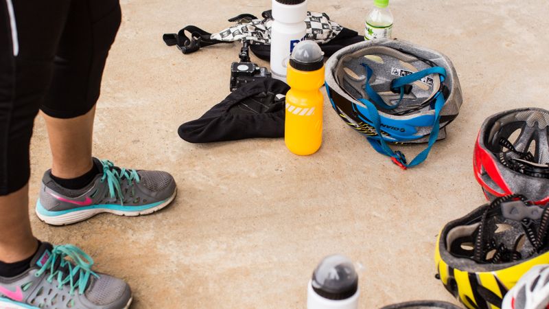 Cascos y bidones de agua en el suelo, equipación de ciclismo