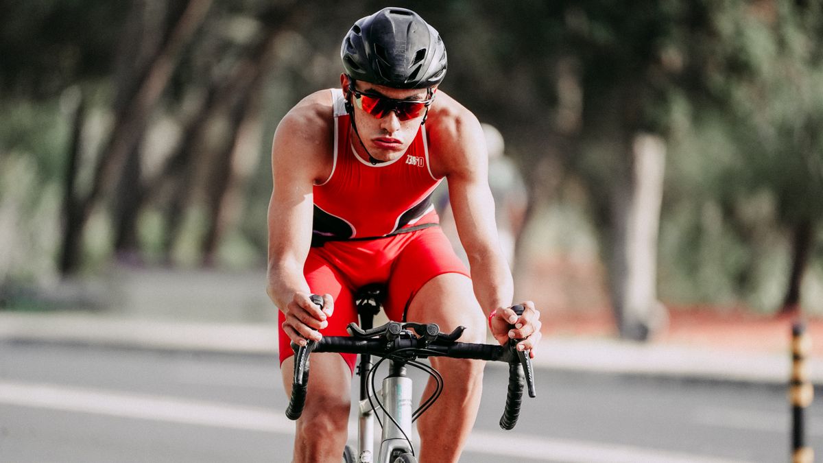 Foto ilustrativa de entrenamiento: ciclista concentrado pedaleando en carretera