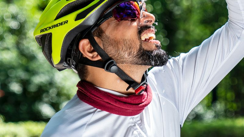 Ciclista refrescándose con agua en un día de mucho calor